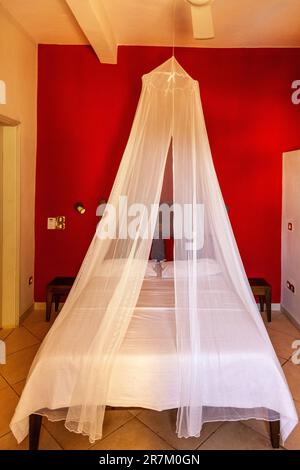 Letto con zanzariera in una camera d'albergo a Bamako, Mali. Foto Stock