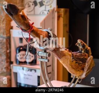 Coscia di suino serrano Iberian Saled Jamon in stand in macelleria spagnola da vicino Foto Stock