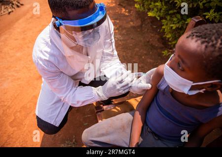 Un medico vaccina un bambino in Africa durante una visita medica Foto Stock