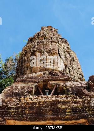 Una statua di pietra di un ritratto di un uomo sulla torre del tempio di Ta Prohm in Cambogia. Foto Stock