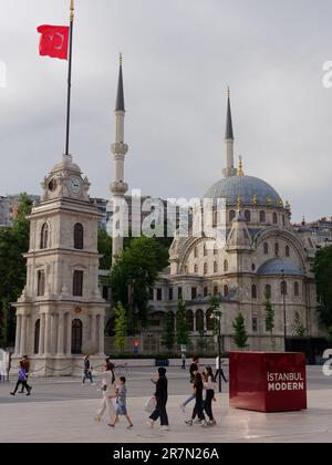 Moschea di Tophana, alias Moschea Nusretiye, con Campanile, Istanbul, Turchia. La gente passeggia davanti godendosi la calda serata. Foto Stock