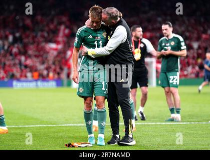 Il Callum Marshall dell'Irlanda del Nord sembra sconsolato mentre il capo allenatore Michael o'Neill li consola in seguito alla sconfitta nella partita di qualificazione UEFA euro 2024 del Gruppo H al Parken Stadium, Copenaghen. Data immagine: Venerdì 16 giugno 2023. Foto Stock