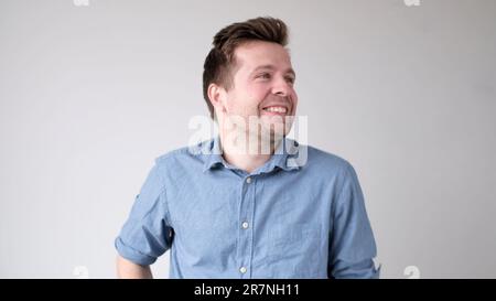 Il giovane europeo guarda con fiducia nella telecamera e sorride Foto Stock