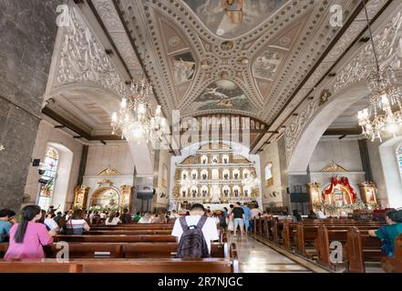 Cebu City,Cebu,Filippine-Gennaio 17 2023: Molti fedeli filippini, vengono a inginocchiarsi, pregano e ringraziano, in questo edificio religiosamente importante,f Foto Stock