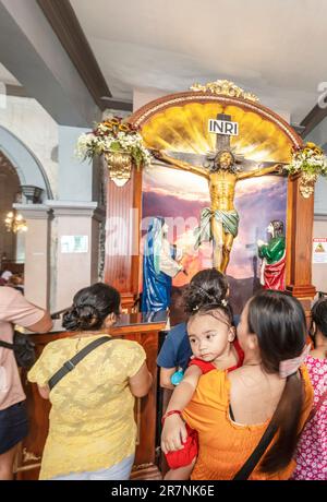Cebu City, Cebu, Filippine-Gennaio 17 2023: Molte famiglie religiose cattoliche, e i loro bambini, visitano il più antico e storicamente importante churc Foto Stock