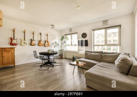 un soggiorno con chitarre appese alla parete e una sedia da ufficio in primo piano - immagine ripresa dall'alto Foto Stock