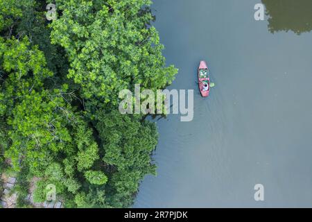 Huzhou, la provincia cinese di Zhejiang. 16th giugno, 2023. Questa foto aerea mostra un villager che si affida a una barca in un fiume nel villaggio Quanxin di Donglin Town, Huzhou, provincia di Zhejiang nella Cina orientale, 16 giugno 2023. Con il Green Rural Revival Program di Zhejiang, Donglin Town si è concentrata sulla costruzione di una splendida campagna basata sulle sue risorse culturali e naturali, facendo ogni sforzo per raggiungere uno sviluppo verde e sostenibile, mantenendo al contempo i guadagni economici. Credit: Xu Yu/Xinhua/Alamy Live News Foto Stock