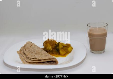 Immagine ravvicinata di Chappthi in stile Kerala, curry all'uovo e tè su sfondo bianco Foto Stock