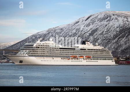 Una maestosa nave da crociera vichinga Venere ormeggiata nel porto di Tromso, contro le montagne innevate Foto Stock