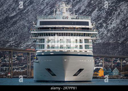 Una maestosa nave da crociera vichinga Venere ormeggiata nel porto di Tromso, contro le montagne innevate Foto Stock