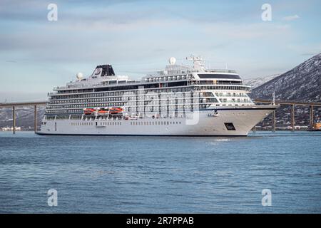 Una maestosa nave da crociera vichinga Venere ormeggiata nel porto di Tromso, contro le montagne innevate Foto Stock