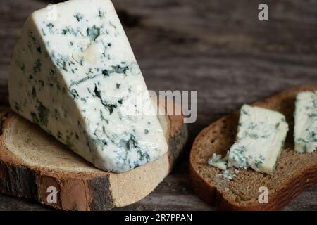 un pezzo di formaggio blu su un tavolo di legno primo piano Foto Stock