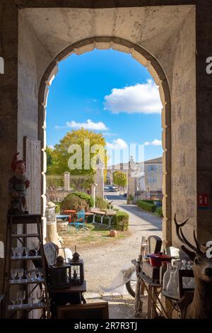 Lectoure, Francia - 5 novembre 2022: Una vista attraverso un portico all'ingresso di un mercato delle pulci in un ospedale in disuso senza persone Foto Stock