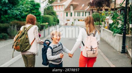 Gruppo di 3 bambini divertenti con zaini, 2 scolaresche e un preschooler, concetto di ritorno a scuola Foto Stock