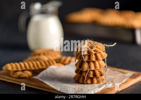 Biscotti con dadi. Biscotti fatti in casa. Una piramide di biscotti su un asse di legno. Sulla tavola di pasticceria. Sfondo grigio. Spazio per il testo. Foto Stock