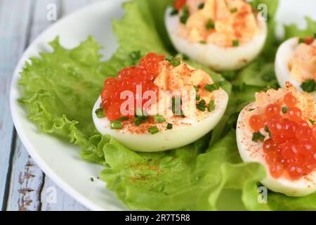Uova ripiene con caviale di salmone sono un antipasto popolare per ogni occasione. Elegantemente decorate e sapientemente condite, saranno sempre una bella A. Foto Stock