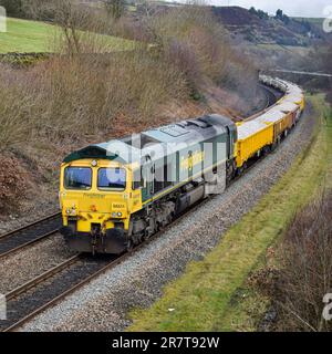 Un Freightliner Class 66 si dirige verso Marsden, trasportando un treno ingegneristico per la Transpennine Route Uprgade. Foto Stock