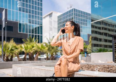 Ritratto di una donna latina executive o di una donna d'affari in un ufficio di un'area di lavoro che parla al telefono seduto Foto Stock