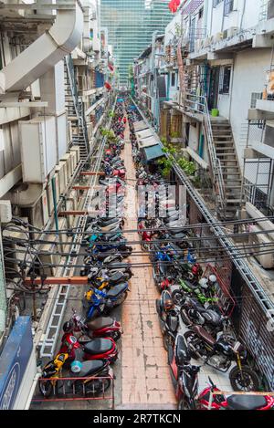 Strada sul cortile con molti scooter e moto parcheggiati nel quartiere Pathum WAN di Bangkok Foto Stock