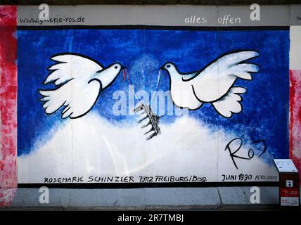 Rosemarie Schinzler, colombe bianche della pace portano la porta di Brandeburgo, opere d'arte sull'ex Muro di Berlino, graffiti, East Side Gallery, Berlino, Germania Foto Stock