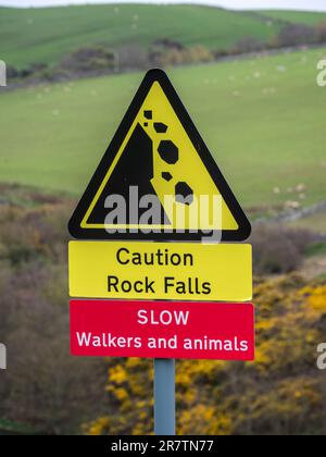 Strada a carreggiata singola a St. Abbs testa, segnale di avvertimento per essere a conoscenza di escursionisti e caduta di roccia, regno unito Foto Stock