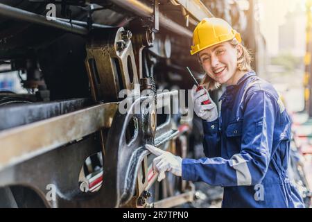 Ingegnere donna lavoro in Diesel locomotive riparazione Negozi sorridente felice Foto Stock