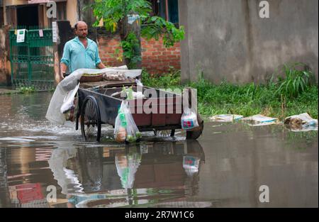 Il 14 giugno 2023, i pendolari svanirono in una strada allagata dopo forti piogge, a Guwahati, Assam, India. Il waterlogging è una scena comune nella città di Guwahati a causa del sistema di drenaggio povero. Credit: David Talukdar/Alamy Live News Foto Stock