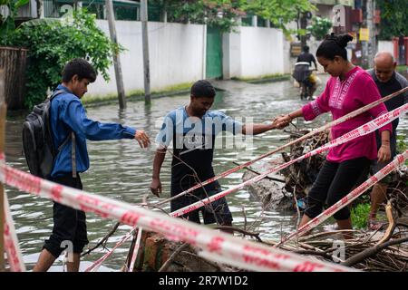 Il 14 giugno 2023, i pendolari svanirono in una strada allagata dopo forti piogge, a Guwahati, Assam, India. Il waterlogging è una scena comune nella città di Guwahati a causa del sistema di drenaggio povero. Credit: David Talukdar/Alamy Live News Foto Stock