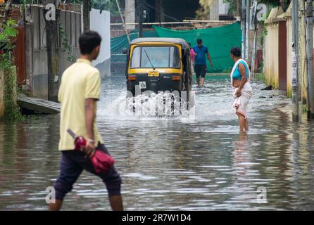 Il 14 giugno 2023, i pendolari svanirono in una strada allagata dopo forti piogge, a Guwahati, Assam, India. Il waterlogging è una scena comune nella città di Guwahati a causa del sistema di drenaggio povero. Credit: David Talukdar/Alamy Live News Foto Stock