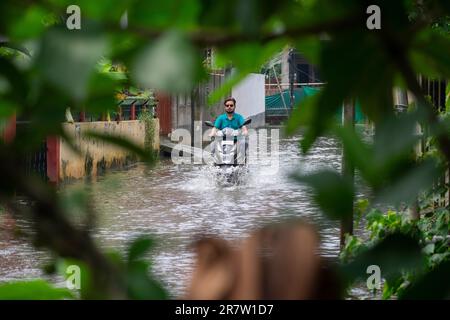 Il 14 giugno 2023, i pendolari svanirono in una strada allagata dopo forti piogge, a Guwahati, Assam, India. Il waterlogging è una scena comune nella città di Guwahati a causa del sistema di drenaggio povero. Credit: David Talukdar/Alamy Live News Foto Stock