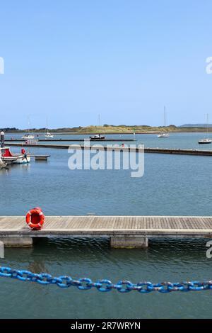 Yacht porto in una giornata estiva con una scialuppa di salvataggio rossa e catena blu Foto Stock