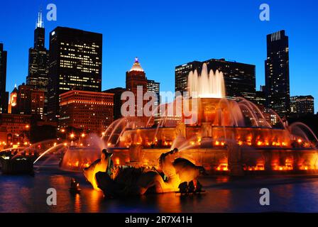 La storica Buckingham Fountain di Grant Park è illuminata al tramonto insieme allo skyline di Chicago Foto Stock