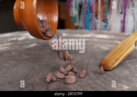 I fagioli di cacao vengono tostati su un piatto tradizionale per preparare il cioccolato Foto Stock