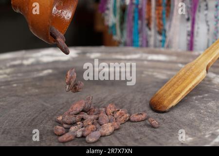 I fagioli di cacao vengono tostati su un piatto tradizionale per preparare il cioccolato Foto Stock