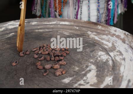 I fagioli di cacao vengono tostati su un piatto tradizionale per preparare il cioccolato Foto Stock