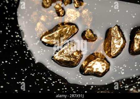 Mucchio di pepite d'oro lucido in acqua, vista in primo piano Foto Stock