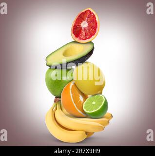 Pila di diversi frutti freschi su fondo sfumato marrone chiaro Foto Stock