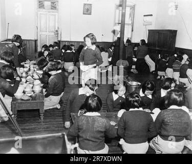 Le ragazze orfano coreane pranzano in un orfanotrofio cattolico durante la guerra di Corea Foto Stock
