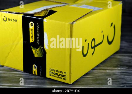 Cairo, Egitto, 12 2023 giugno: Mezzogiorno shopping online consegna pacco scatola gialla, Noon.com express per la consegna rapida e facile ritorno, mezzogiorno è un e-commercc Foto Stock