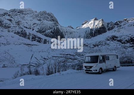 Motorhome e scenario di montagna ghiacciato, inverno, Nusfjord, Lofoten, Norvegia Foto Stock