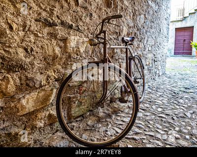 Vecchia bicicletta in un vicolo di un villaggio italiano Foto Stock