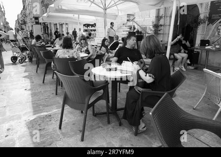 Fotografia in bianco e nero di un'affollata caffetteria all'aperto in Republic Street di Valletta, Malta Foto Stock