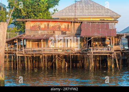 Case a palafitte lungo il fiume Chao Phraya nella megacity Bangkok. In molte parti, le case semplici sono state demolite e sono sostituite da Foto Stock