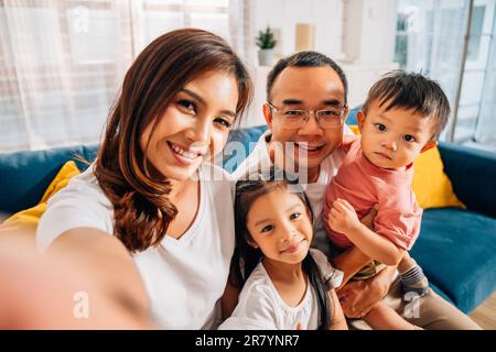 Felice famiglia padre madre e bambini scattando foto selfie Foto Stock