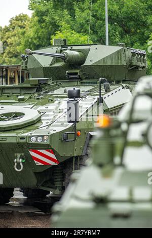 Carri armati armati e veicoli da combattimento per la fanteria militare pronti a muoversi sotto la pioggia, forza terrestre lituana, forza di risposta NATO, verticale Foto Stock