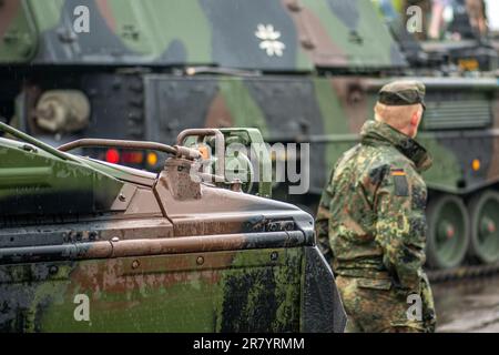 Soldato tedesco che cammina vicino ai carri armati armati in movimento obice semovente Panzerhaubitze 2000 o PzH 2000, esercito tedesco Foto Stock