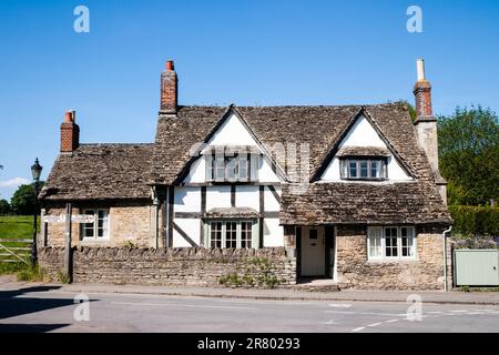 La Porch House, medievale grande casa a graticcio e in gesso con vecchio tradizionale cartello inglese in legno fuori. Lacock, nelle Cotswolds. Foto Stock