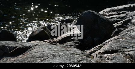 Effetto ondulazione sulla riva del mare nell'arcipelago la sera d'estate Foto Stock