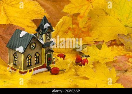 Bella creative composizione d'autunno. piccolo giocattolo casa. essiccato bright foglie, close up Foto Stock
