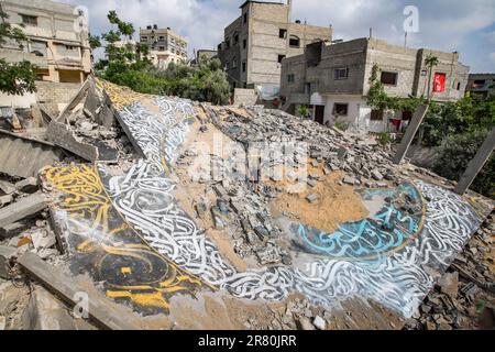 Gaza, Palestina. 18th giugno, 2023. Una seduta palestinese vicino alla calligrafia murale araba disegnata dall'artista graffiti Ayman Alhossary, 35 in casa distrutta da Israele, in recenti combattimenti israelo-Gaza, a Beit Lahiya, nella striscia di Gaza settentrionale, il 18 giugno 2023. Foto di Ramez Habboub/ABACAPRESS.COM Credit: Abaca Press/Alamy Live News Foto Stock